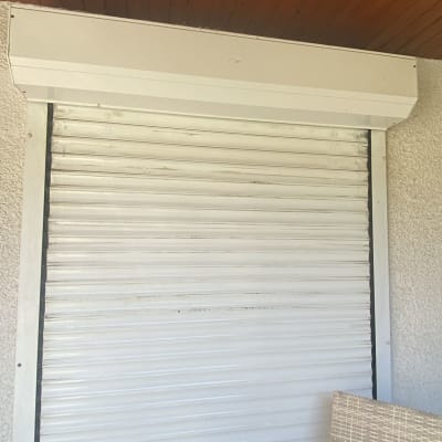 תריס גלילה לבן מותקן על קיר חיצוני