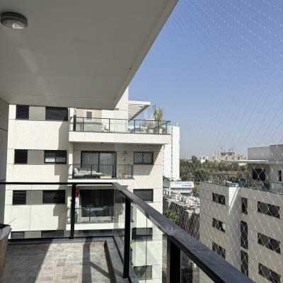 רשת שקופה מותקנת על מרפסת למניעת כניסת יונים