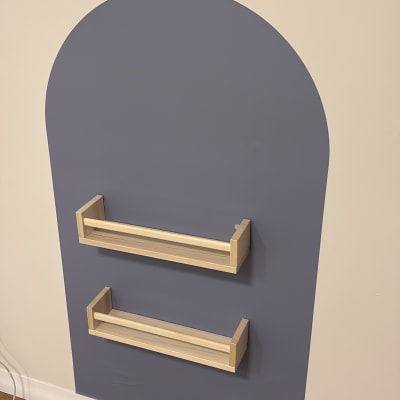 מדף עץ מותקן על קיר צבוע בצבע כחול כהה