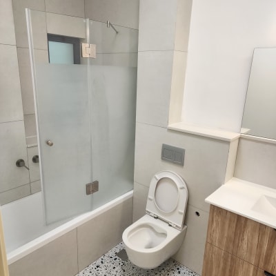 חדר אמבטיה נקי עם שירותים ומקלחת