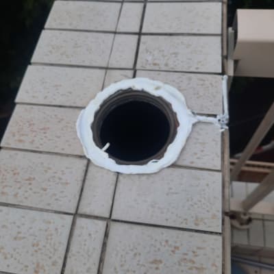 חור עגול ברצפה עם איטום לבן סביבו