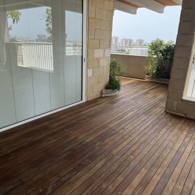 מרפסת עץ עם צמחים ונוף עירוני