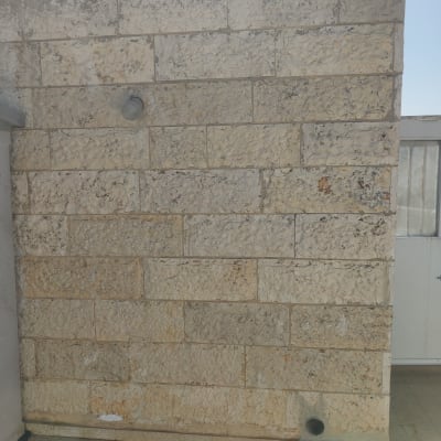 קיר אבן עם צינור קטן בתחתית