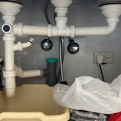צנרת פלסטיק מתחת לכיור עם חיבורים