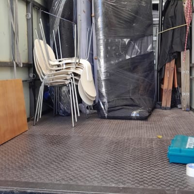 משאית הובלה עם רהיטים עטופים וערימת כיסאות