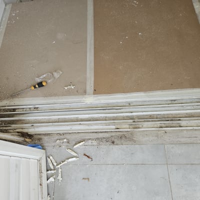 מסילות תריסים עם לכלוך וכלי עבודה על הרצפה