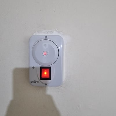 מתג חכם על קיר עם נורית חיווי אדומה