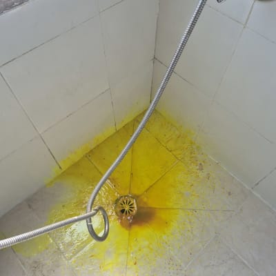 נזילה במקלחת עם כתם צהוב סביב הניקוז