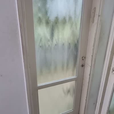 דלת זכוכית חלבית עם מסגרת לבנה