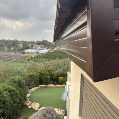 תקריב של גג עם נוף של גינה ושמים מעוננים