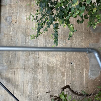 צינור מתכת על גג בטון עם צמחייה מסביב