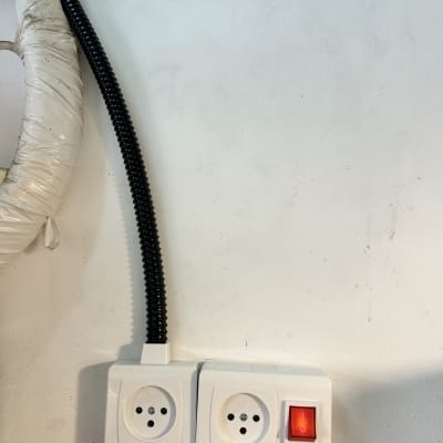 שני שקעי חשמל עם מתג אדום על קיר לבן