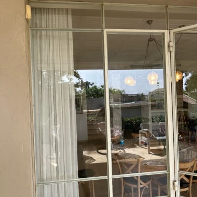 חלון זכוכית גדול עם וילון לבן מאחוריו