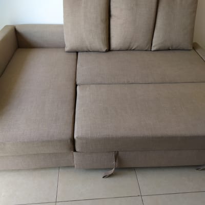 ספה חומה עם כריות על רצפת אריחים