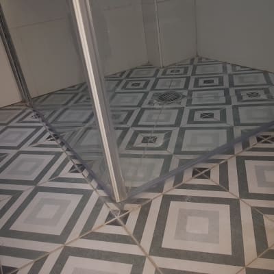 רצפת מקלחת עם אריחים ודלת זכוכית