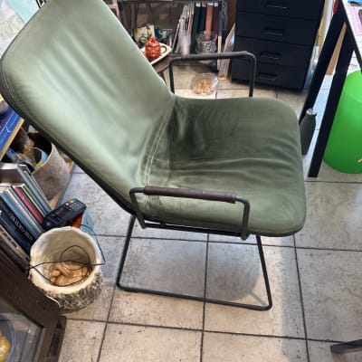 כיסא ירוק בחדר עם חפצי נוי וספרים