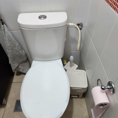 אסלה עם צינור מים ומיכל הדחה