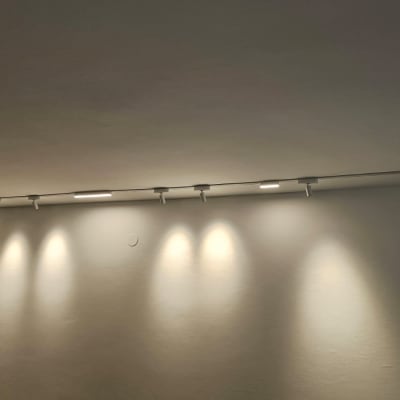 תאורת מסילה עם מספר פנסים על תקרה לבנה