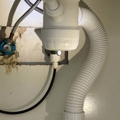 צינור ניקוז לבן מתחת לכיור עם חיבורים