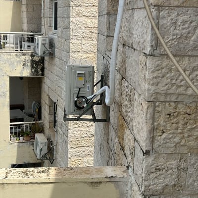 יחידת מיזוג אוויר מותקנת על קיר חיצוני של בניין.