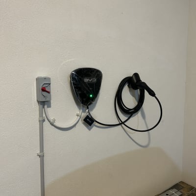 מטען לרכב חשמלי מותקן על קיר עם כבל טעינה