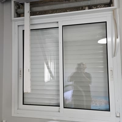 תריסים לבנים עם חלקים שבורים וחלון זכוכית