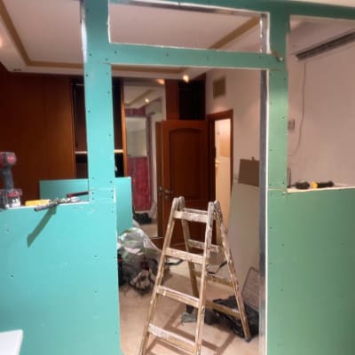 קיר גבס בבנייה עם כלי עבודה וסולם