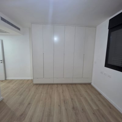 רצפת פרקט בחדר עם ארון קיר לבן