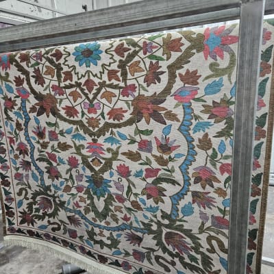 שטיח צבעוני תלוי על מתקן מתכת לניקוי