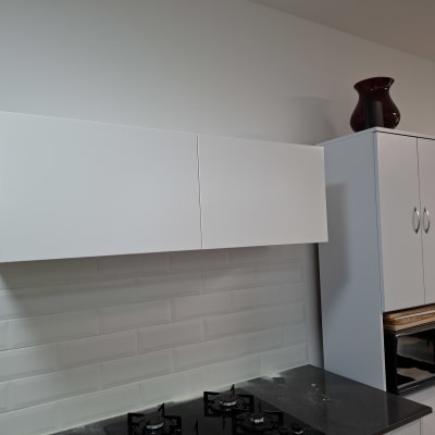 ארונות מטבח לבנים מעל כיריים שחורים