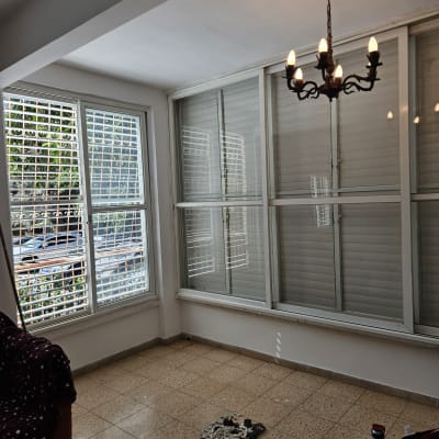 חדר עם תריסים וכלים לתיקון תריסים על הרצפה