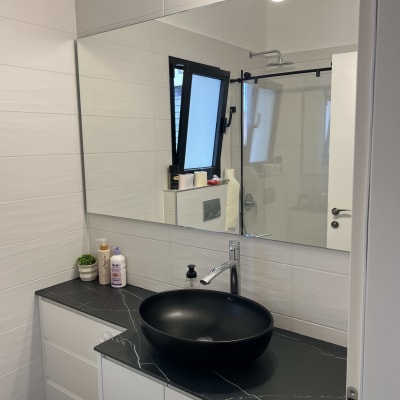 מראה גדולה מעל כיור בחדר אמבטיה מודרני