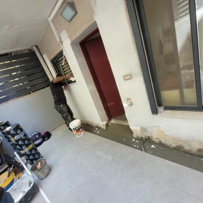 אדם מורח חומר איטום על קיר חיצוני