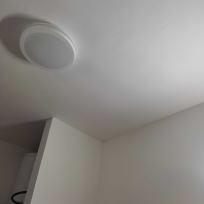 תקרה וקיר צבועים בלבן עם מנורה עגולה