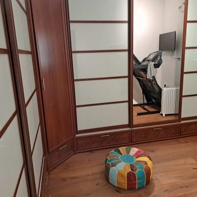 חדר עם ארון, הליכון וכרית צבעונית על הרצפה