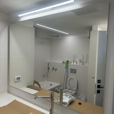 מראה גדולה עם מסגרת דקה בחדר אמבטיה