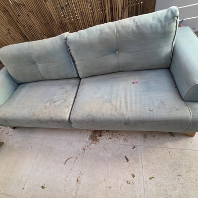 ספה מלוכלכת עם כתמים על הרצפה