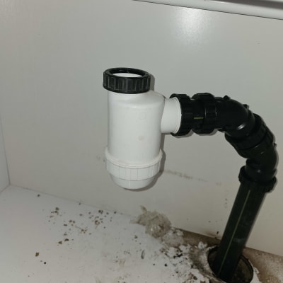 צינור ביוב מתחת לכיור עם לכלוך סביבו