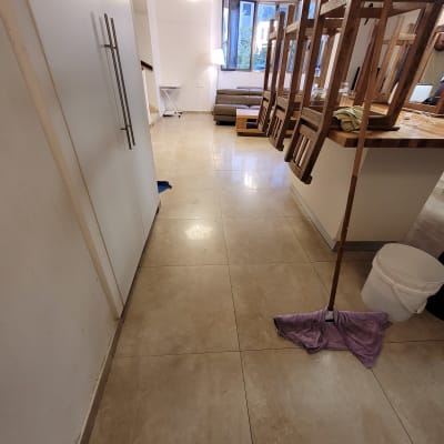 רצפה נקייה עם מגב ודלי בחדר מואר