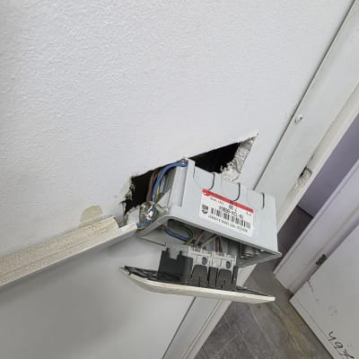 תיבת חשמל פתוחה עם חוטים חשמליים בקיר