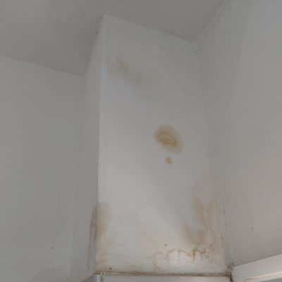 כתם רטיבות על קיר לבן בפינה עליונה