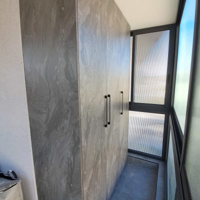 ארון עץ עם ידיות מתכת במרפסת סגורה