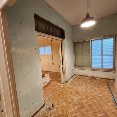 חדר עם קירות מתקלפים, שאריות צבע על הרצפה