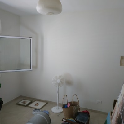 ציור על קנבס מונח על הרצפה ליד קיר לבן