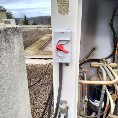 מתג חשמלי עם ידית אדומה על ארון חשמל