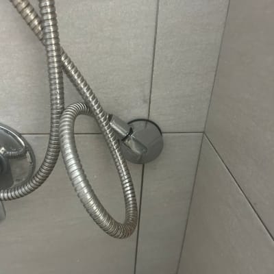 צינור מתכת מחובר לקיר במקלחת