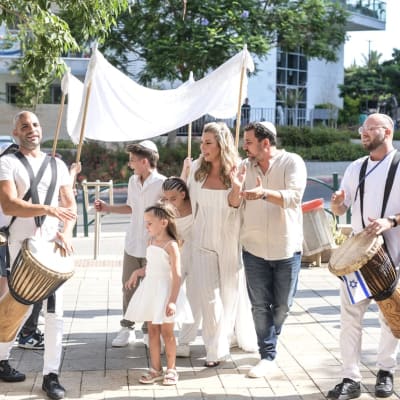 אנשים צועדים ברחוב עם תופים ודגל ישראל