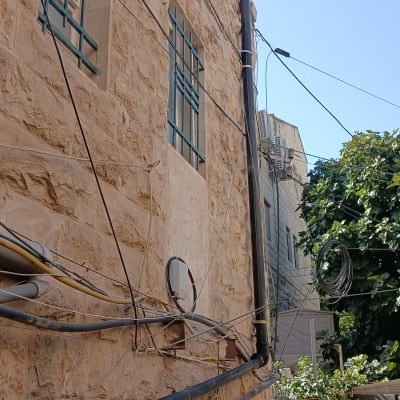 התקנת צנרת אינסטלציה ומרזב חיצוני על חזית בניין אבן בגובה