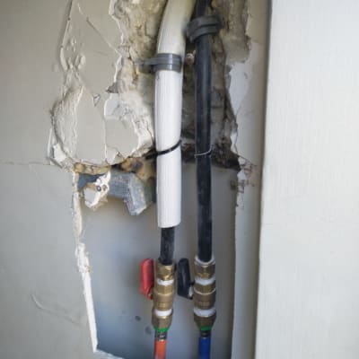 צינורות מים עם ברזים בקיר פתוח