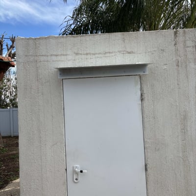 דלת לבנה עם מנעול, עצים ברקע